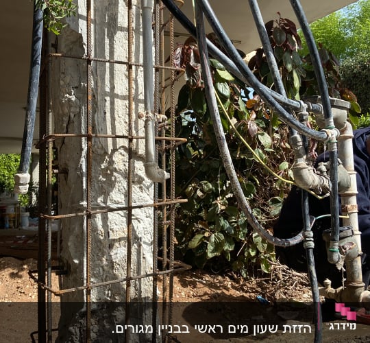 צינורות מים מחוברים לעמוד בטון עם ברזים